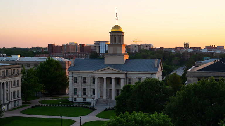 sun setting behind the UI capitol building.